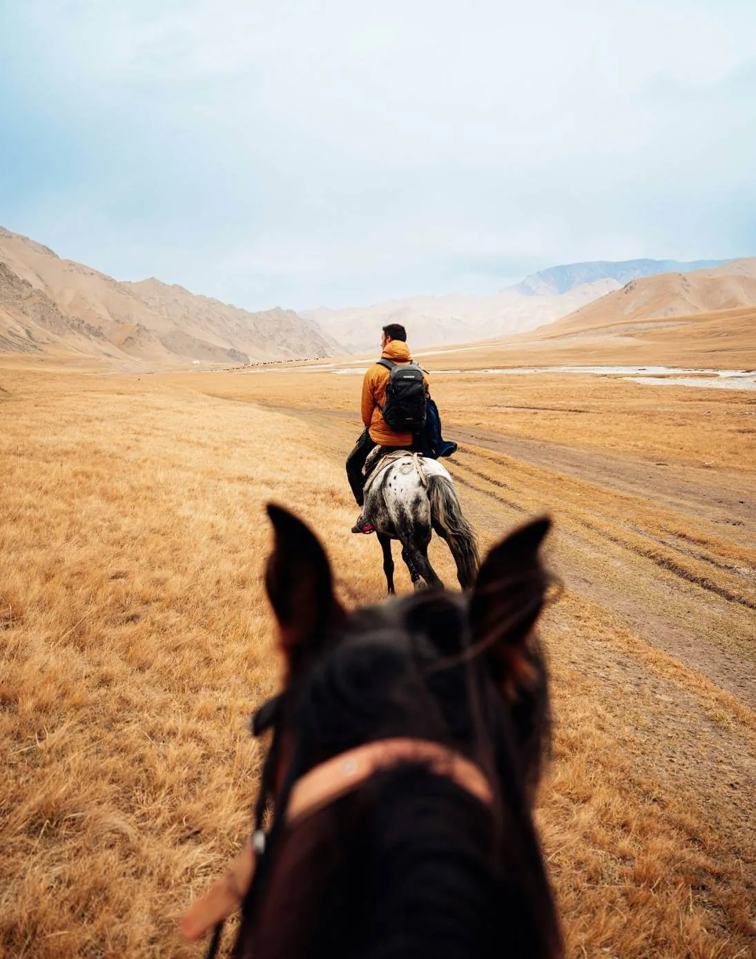 Riding on horseback across a mountain valley