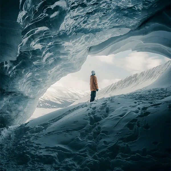 Traveller standing in a glacier ice cave