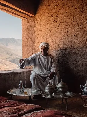 Host pouring mint tea in a traditional mountain home