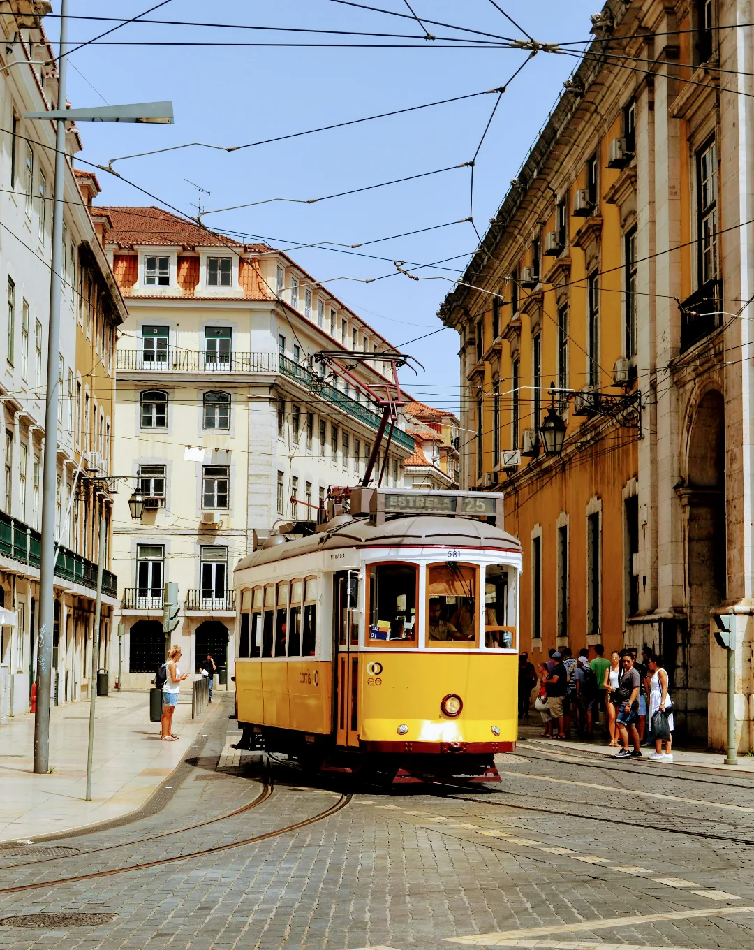 Yellow tram on a hilly street in Lisbon
