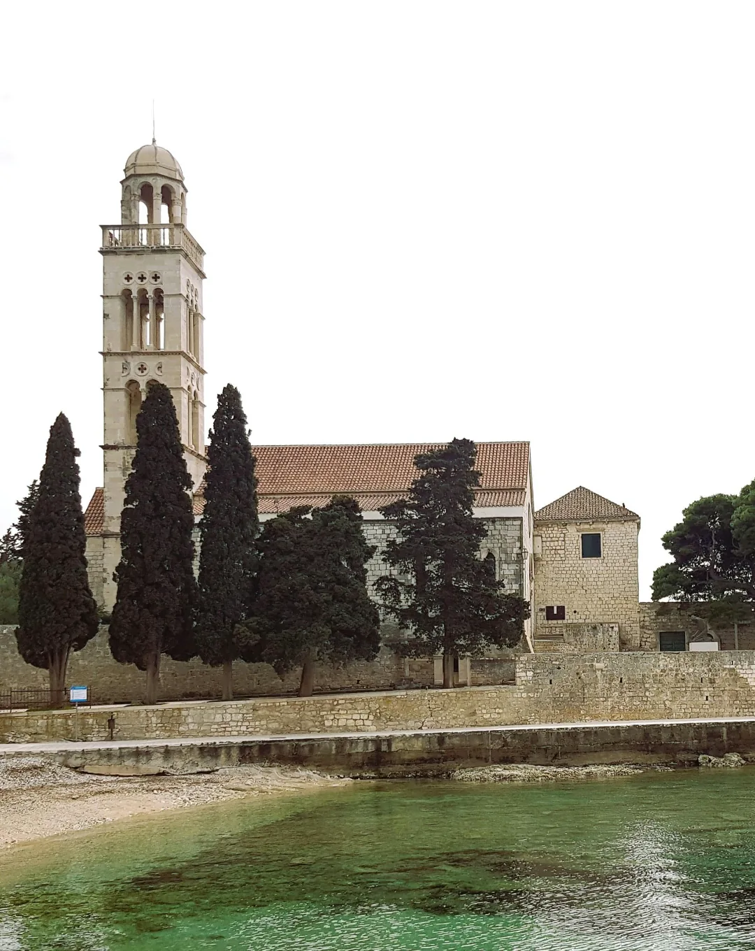 Bell tower and monastery by the water on the Dalmatian coast