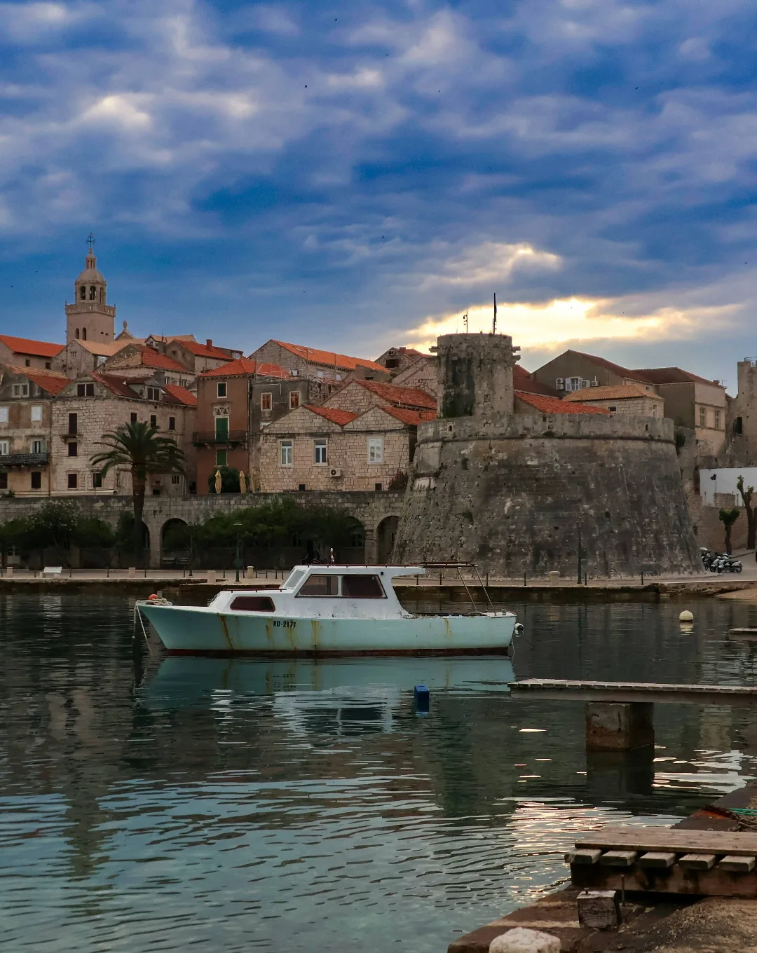 Old town harbour with a boat at dusk