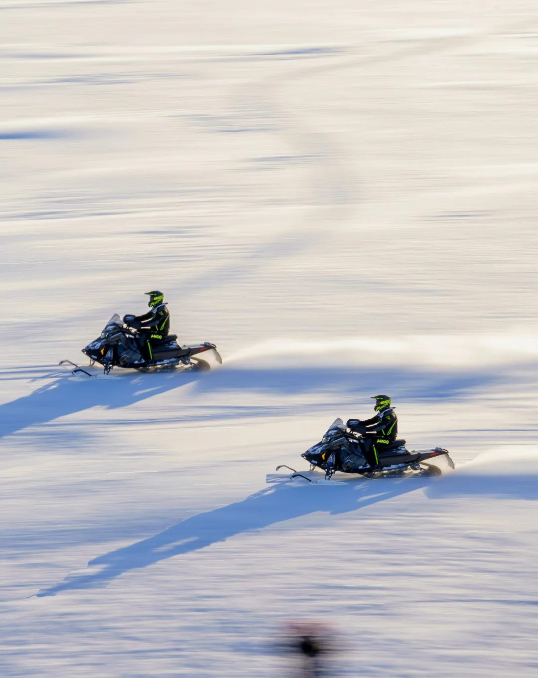 Snowmobiles crossing a snowfield in Lapland