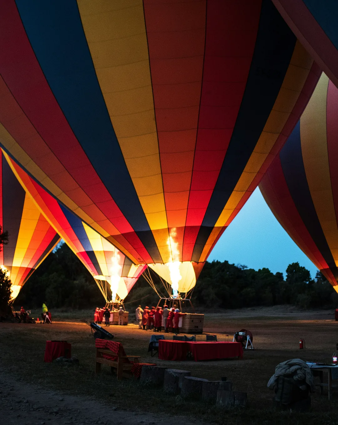 Hot-air balloons being inflated at dawn in the Masai Mara