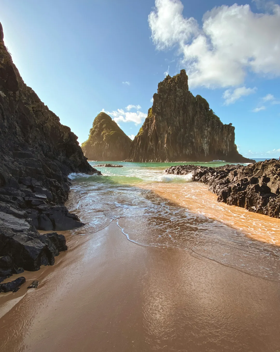 Secluded beach below rocky peaks in Fernando de Noronha