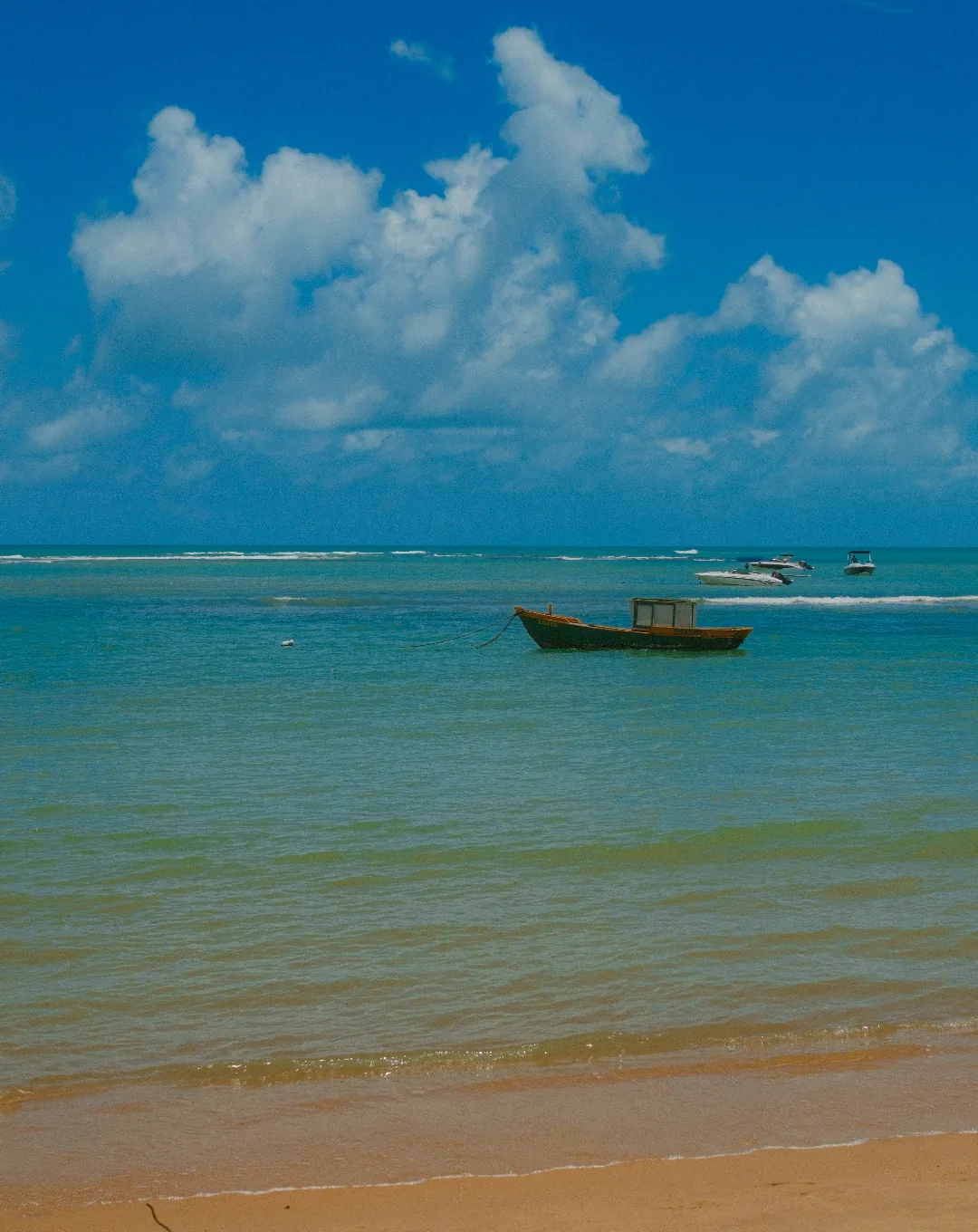 Boat on the shallow turquoise sea off the Brazilian coast